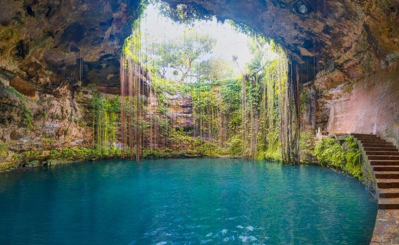 Turquoise cenote with hanging vines